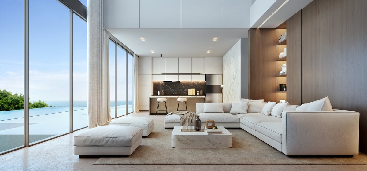 A luxury living room with a white sofa, pool and sea view
